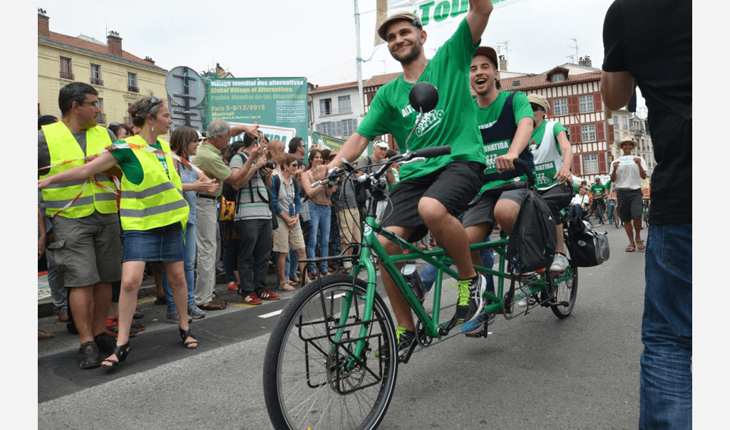 Personnes débutants le tour Alternatiba à vélo entourés d'une foule