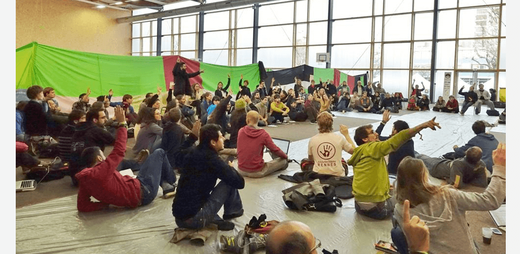 Groupe de personnes assises en cercle dans un gymnase