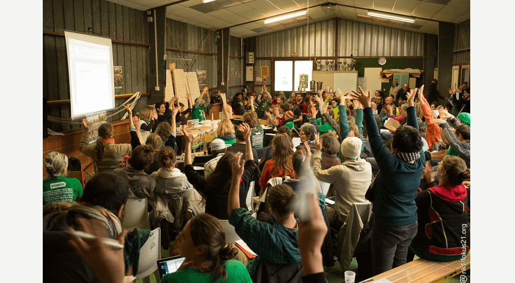 Groupe de personne en réunion et levant les mains en l'air