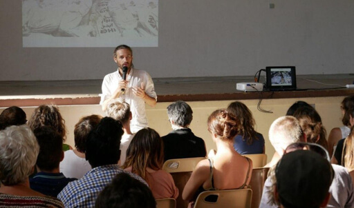 Un orateur devant une salle pleine donnant une conférence